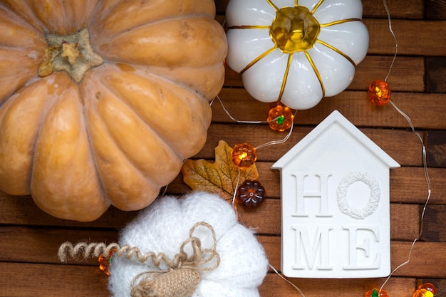 Cozy layout on a wooden background of slats with pumpkins autumn leaves a house and keys autumn mood Halloween housing relocation mortgage insurance