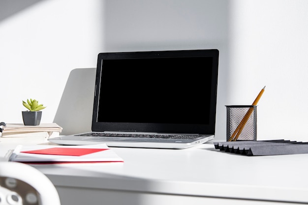 Cozy modern workspace with computer and office supplies near the window