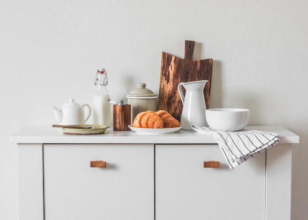 Cozy morning and breakfast preparation croissants dishes on the table in the scandinavian style kitchen