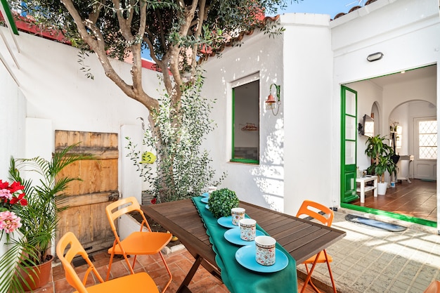 Cozy patio with tree and table served with cups for tea