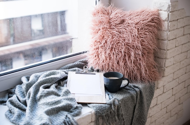 Cozy place on home windowsill pillow and blanket