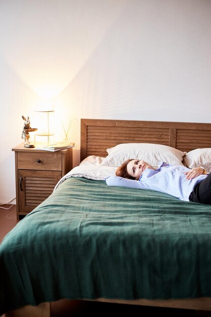 Cozy portrait of millennial female relaxing on cozy bed Bedroom with modern interior