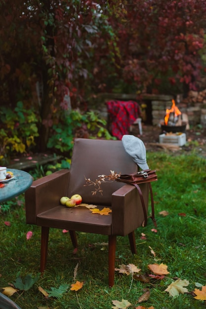 Cozy recreation area in the autumn in the backyard with a\
campfire and a blanket and a hot drink