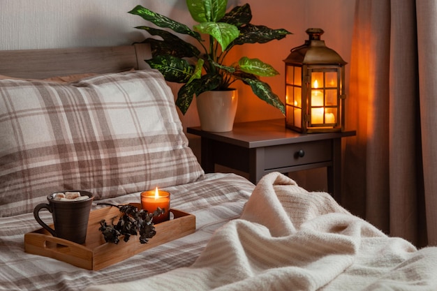 Cozy scandinavian bedroom interior in natural tones blanket lantern houseplants