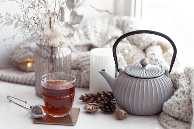Accogliente composizione scandinava con teiera un bicchiere di tè e dettagli decorativi