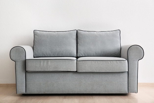 Cozy sofa on light wall background