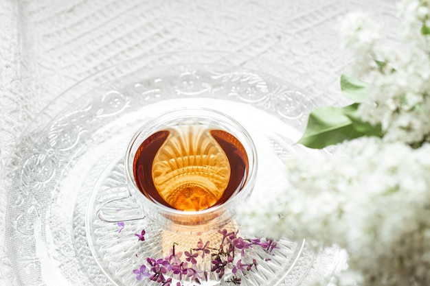 Cozy spring composition with tea and blooming lilac. Top view, flat lay