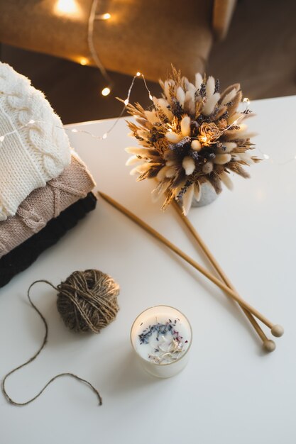 cozy still life with candle knitted sweater decorations and bokeh lights surface