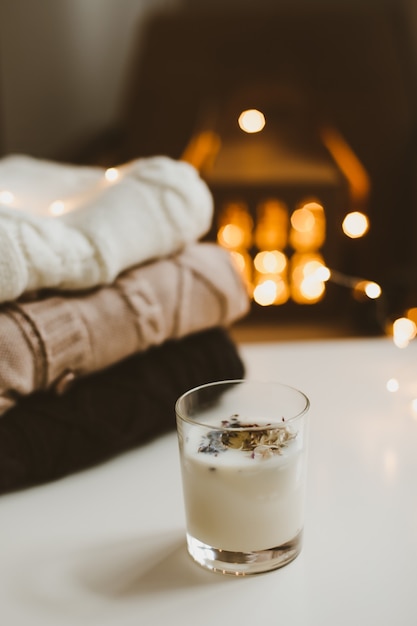 Photo cozy still life with candle knitted sweater decorations and bokeh lights surface