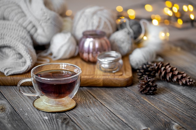 Cozy still life with tea and decorative items, glowing lights.