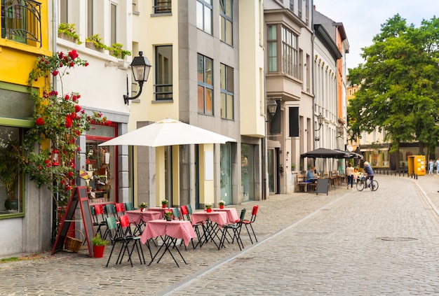 Cozy street cafe decorated with flowers in old European town.