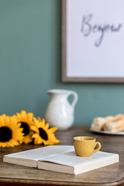 Photo cozy and stylish composition of creative dining room with frame, wooden consola, sunflowers and personal accessories.