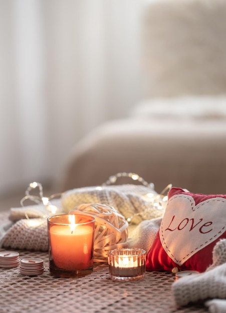 Accogliente sfondo di san valentino con una candela e un cuore decorativo