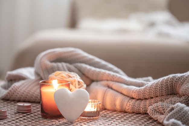 Cozy valentines day background with a candle and a decorative heart