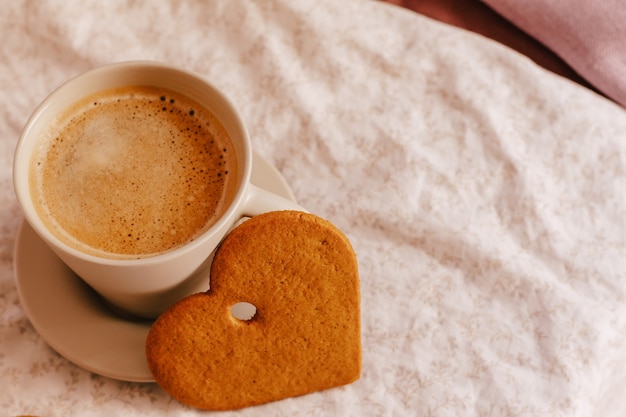 Cozy winter or autumn morning at home. Hot coffee, cookies warm blanket and garland, Swedish hygge concept.