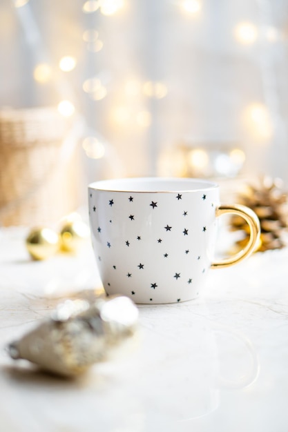 Cozy winter holiday decoration Christmas lights and coffee cup with decor details real home