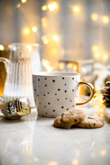 Cozy winter holiday decoration Christmas lights and coffee cup with decor details real home