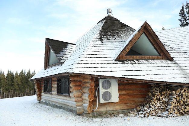 Accogliente casa in legno con neve in giornata invernale