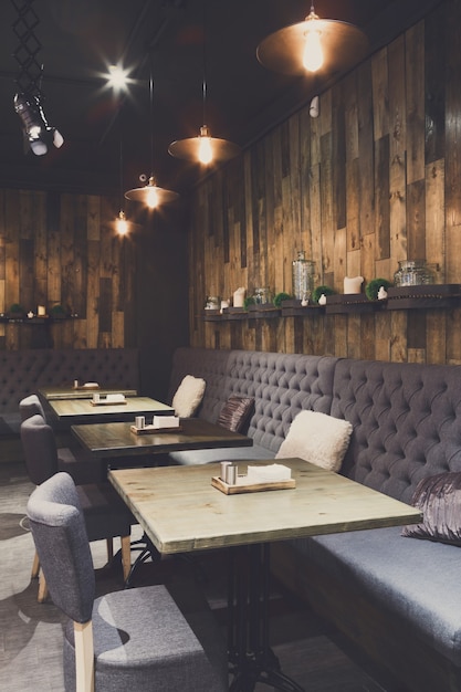 Cozy wooden interior of restaurant, copy space. Comfortable modern dining place, contemporary design background