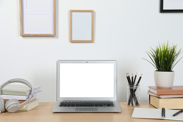 Cozy workspace with laptop and stationery on wooden desk at home