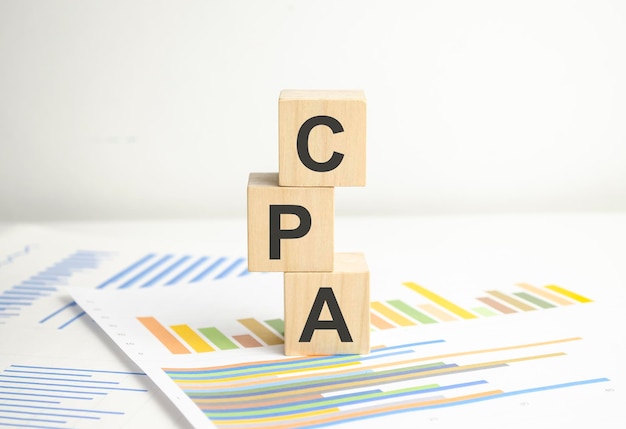 CPA gecertificeerd openbaar accountant symbool Concept woorden CPA gecertificeerd openbaar accountant op houten blokken met grafieken