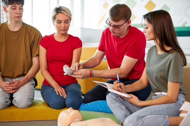 CPR class with male instructor speaking and demonstrating help