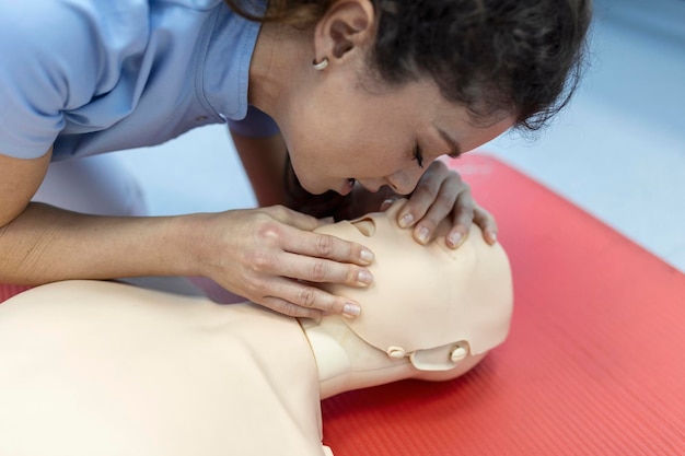 Cpr-les met instructeurs die praten en eerstehulpcompressies demonstreren en reanimatieprocedure cpr-dummy