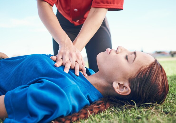 Photo cpr outdoor and hands on chest women and help on a field resuscitation and medical emergency closeup player outside and heart attack with volunteer accident and first aid to rescue a person