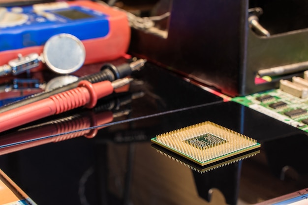 CPU-processorchip met andere apparatuur op de werkplek van de ingenieur van de zwarte tafel Stock Photo