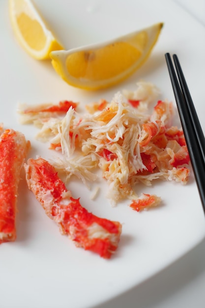 Crab meat and lemon on a white plate