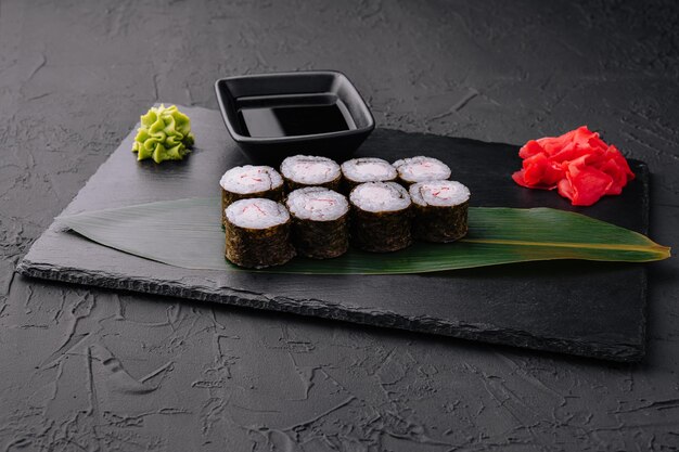 Crab stick maki sushi on black tray