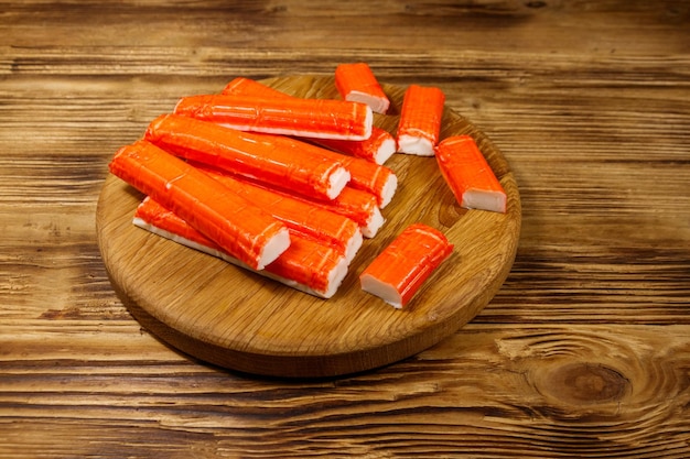 Crab sticks on cutting board on wooden table