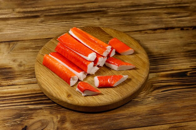 Crab sticks on cutting board on wooden table