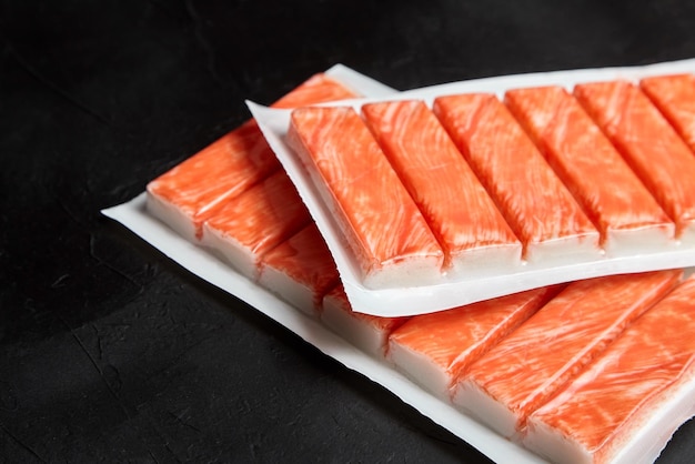 Crab sticks or imitation crab meat on black table