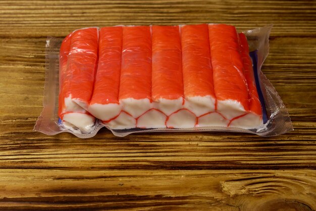 Crab sticks in vacuum pack on wooden table