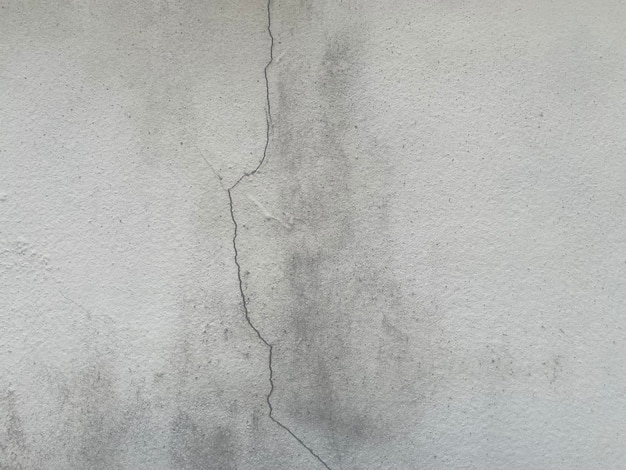 A crack in a gray wall that has been painted black.