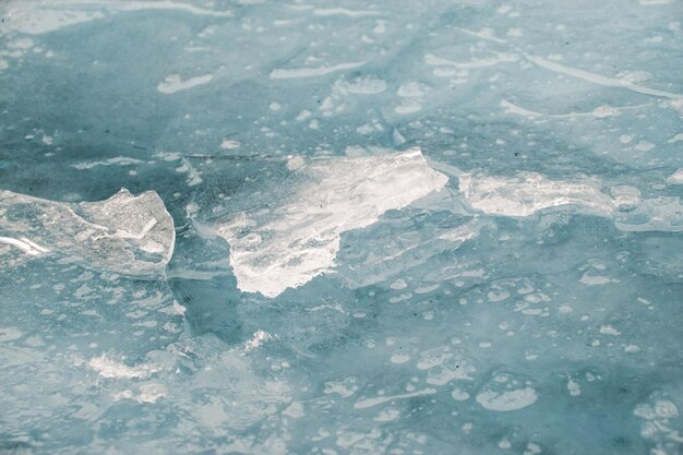 Cracked and broken ice on water close up