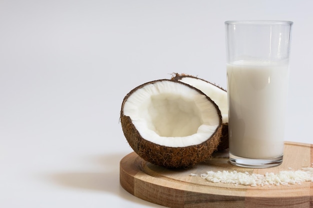 a cracked coconut a glass of coconut milk and desiccated coconut flakes