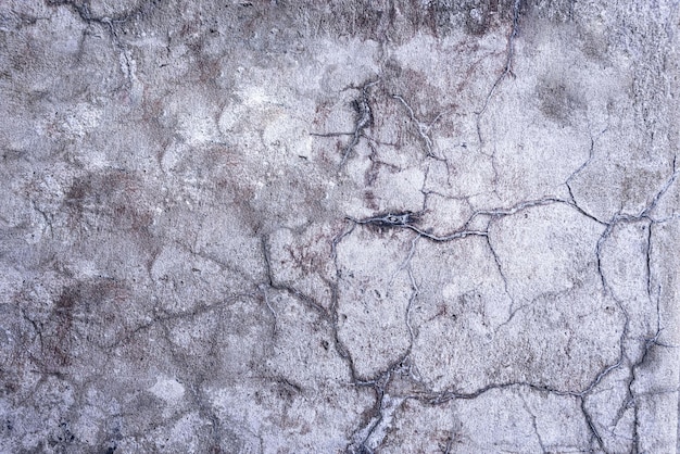 Cracked concrete wall covered with a gray cement texture as the background