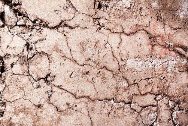 Cracked concrete wall covered with orange cement texture as background