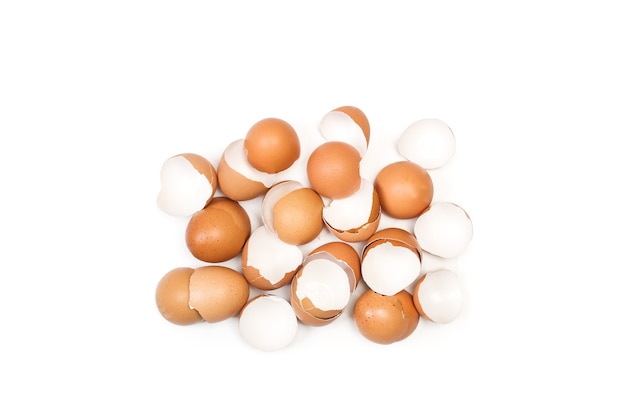 Cracked eggshells on a white background in a top view