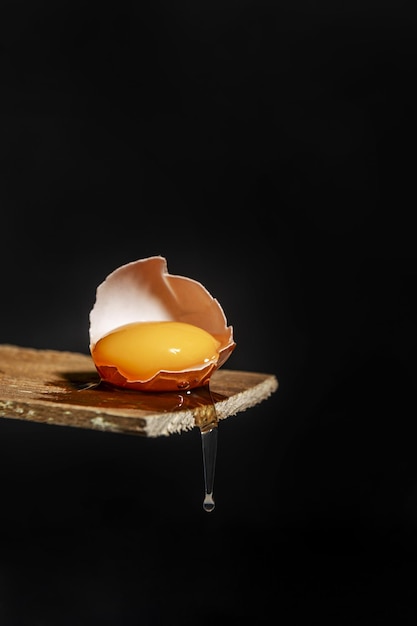 A cracked raw egg with white dripping down