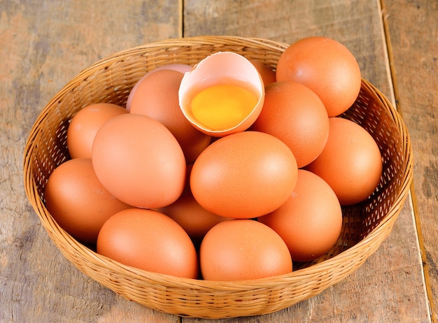 Cracked raw eggs on in wooden bowl