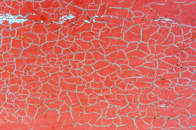 Cracked red paint on a metal surface