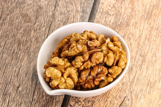 Cracked unshelled walnut in the bowl