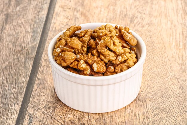 Photo cracked unshelled walnut in the bowl