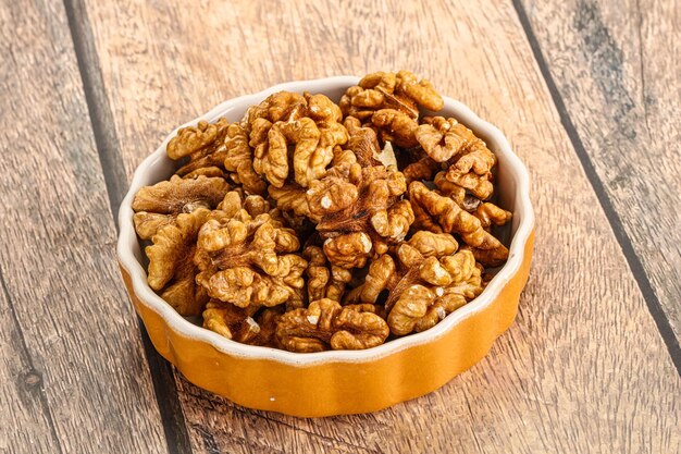 Cracked unshelled walnut nuts in the bowl