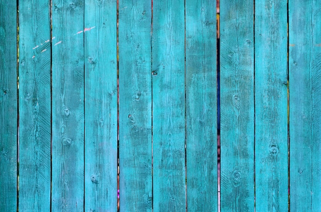 ひびの入った風化グリーンとブルーの塗られた木の板の質感
