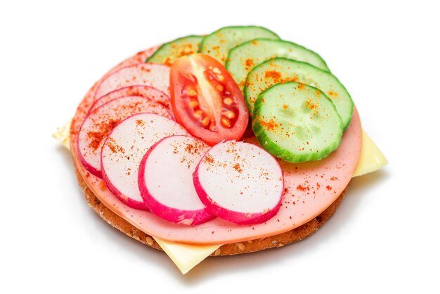 Cracker sandwich with fresh cucumber cheese sausage radish and tomato - isolated