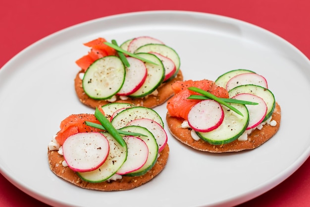 Cracker sandwiches with salmon cucumber radish cottage cheese and green onions